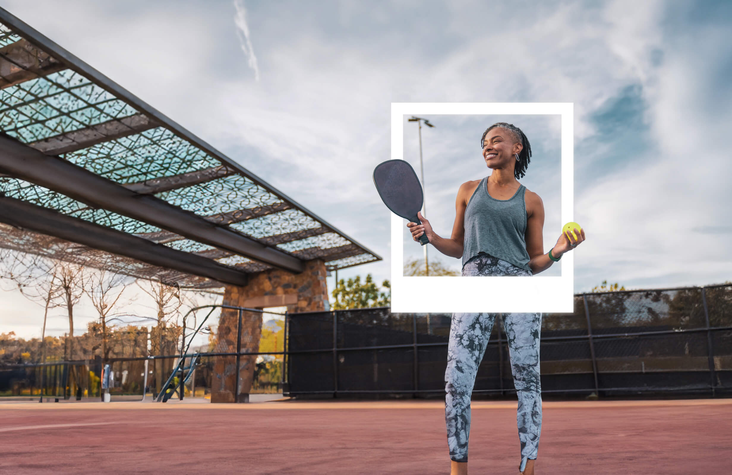 Woman smiling and holding a paddleball racquet and ball. 